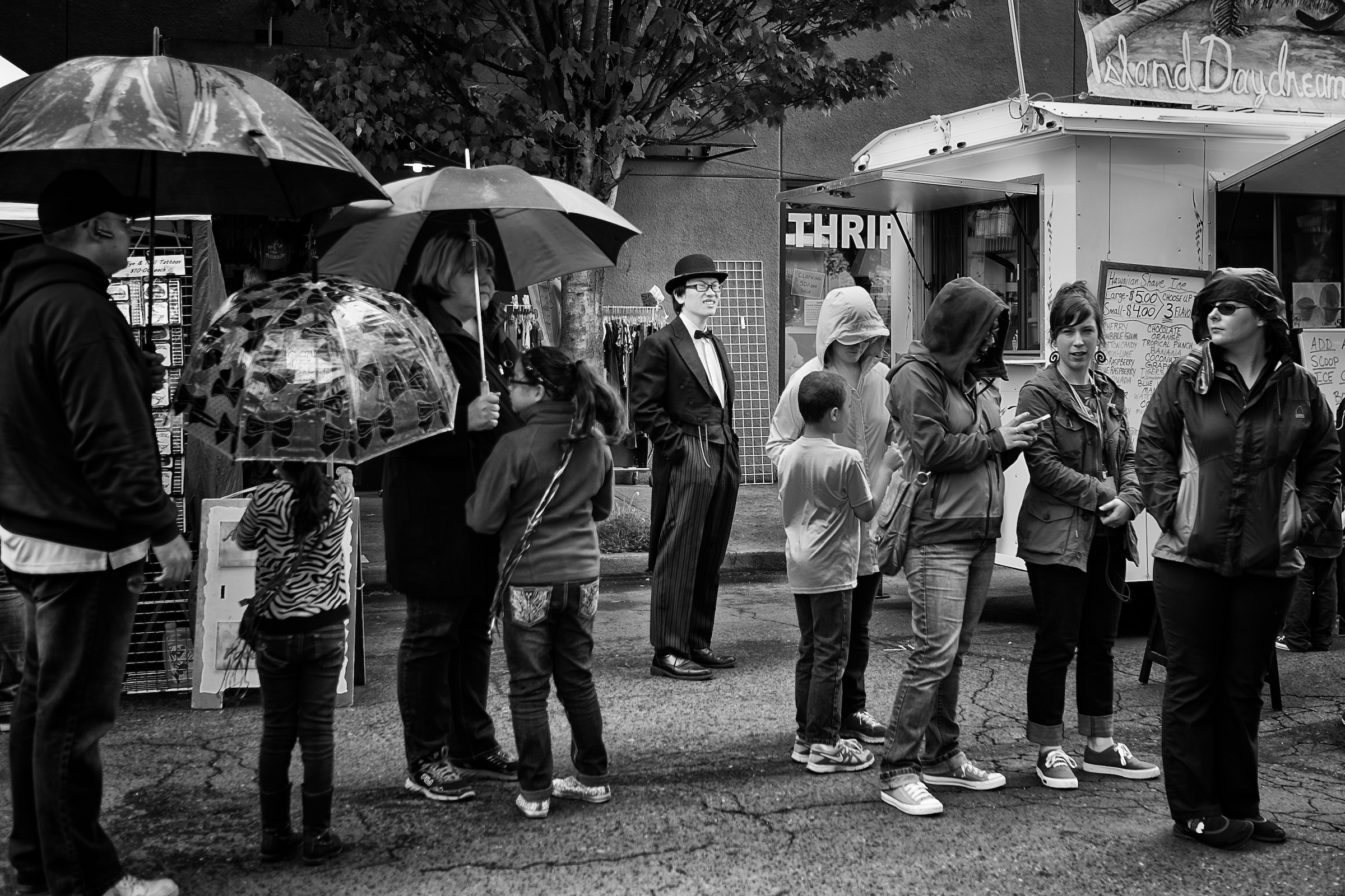 A distinguished gentleman wearing a tailored suit and bowler hat strolling through the St. Johns neighborhood in Portland Oregon